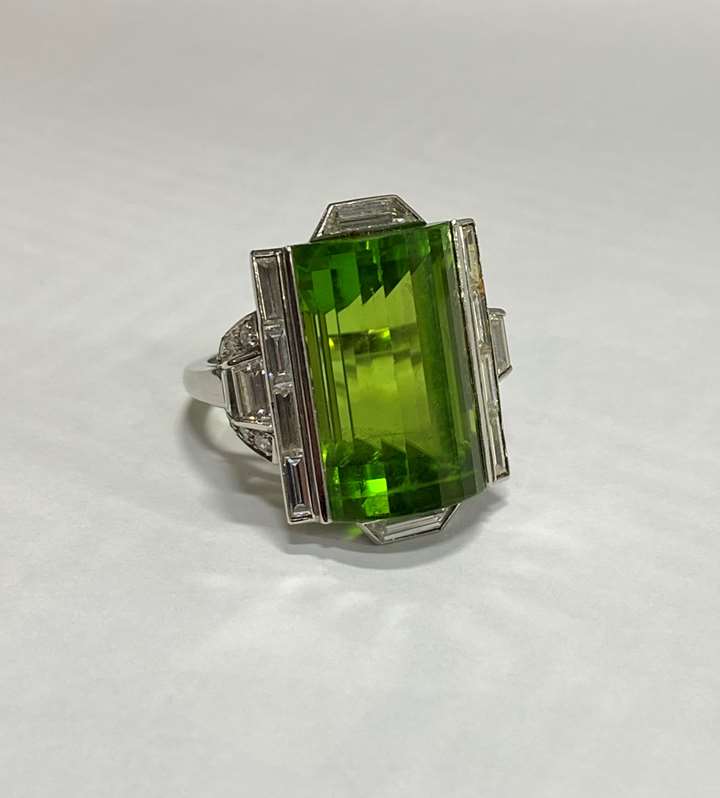 Late Art Deco fancy peridot and diamond dress ring, c.1940, the rectangular peridot arch-topped and step line facetted,